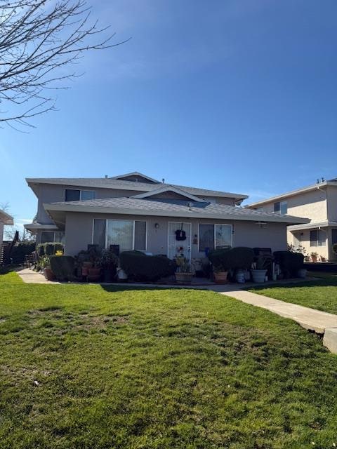 view of front of property with a front yard and stucco siding