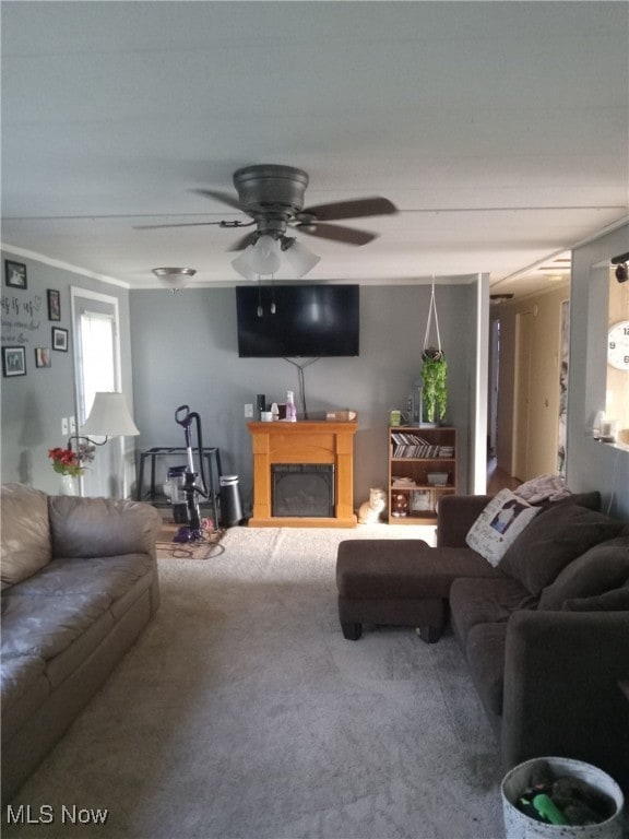Living room with carpet flooring, a fireplace, and ceiling fan