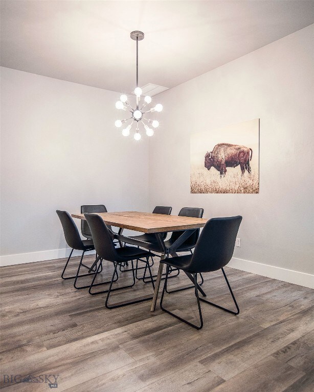 Dining area with a chandelier and dark hardwood /