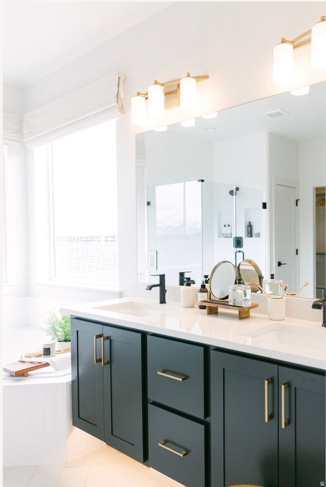 Full bathroom with a bath, double vanity, and light tile patterned flooring