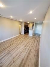 Unfurnished living room with recessed lighting, baseboards, and wood finished floors