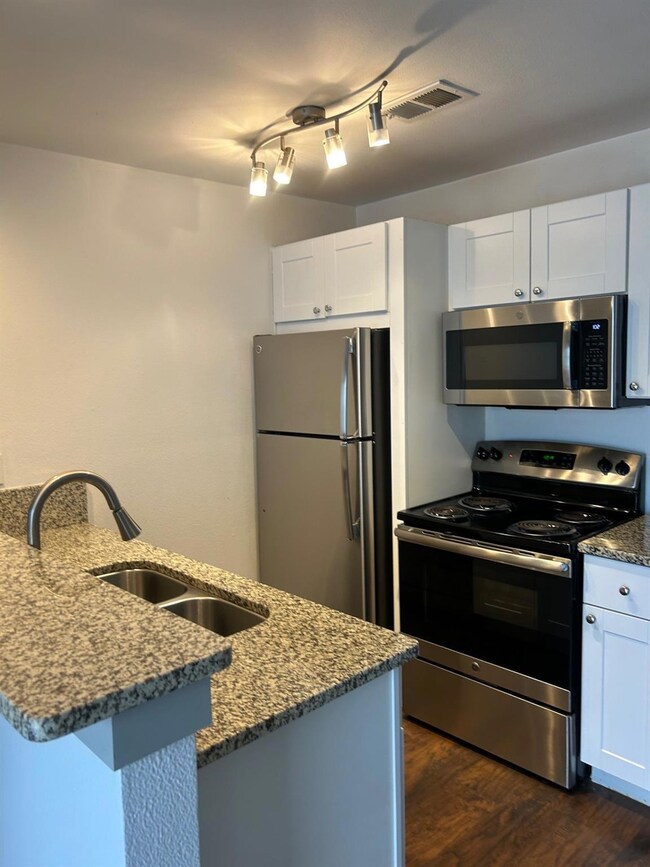 Kitchen with visible vents, dark wood-type floorin