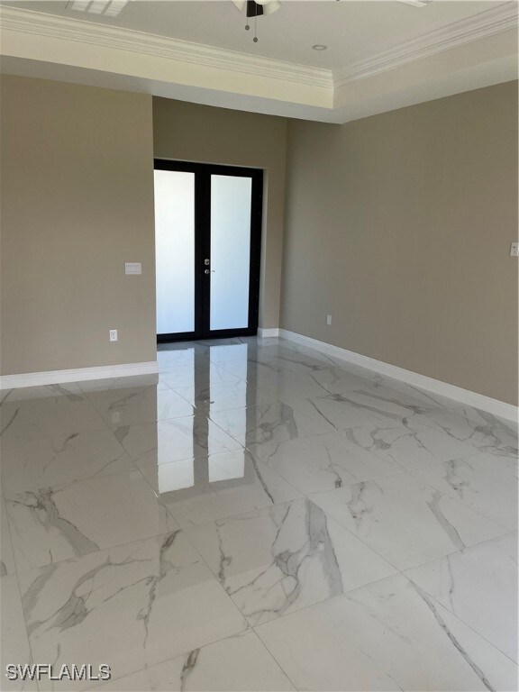 Unfurnished room featuring crown molding, a tray c