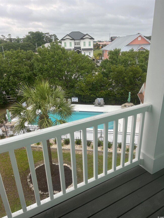 Balcony featuring view of pool area