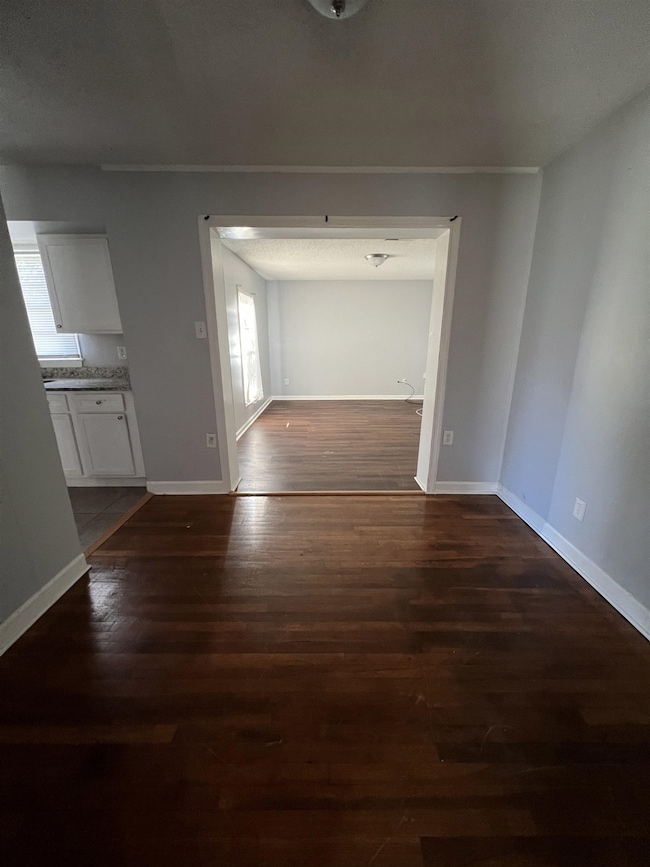 Unfurnished living room with healthy amount of natural light and dark wood finished floors