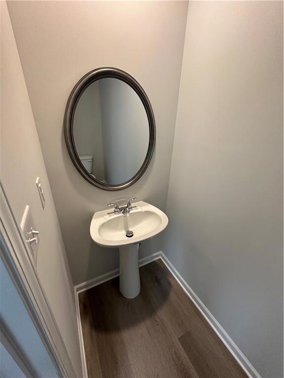 Bathroom with wood finished floors and baseboards