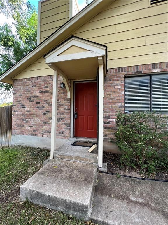 Entrance to property featuring a chimney, brick s