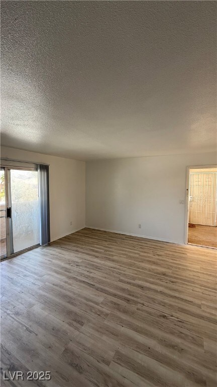 Unfurnished room with a textured ceiling and wood