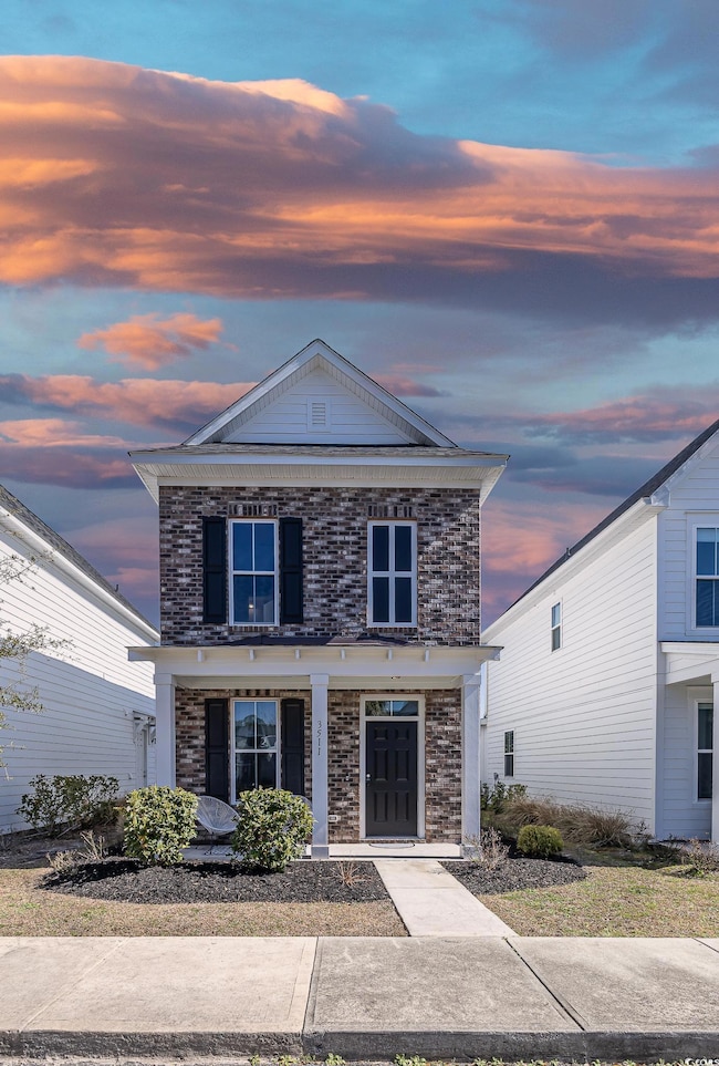View of front of property with a porch and brick s