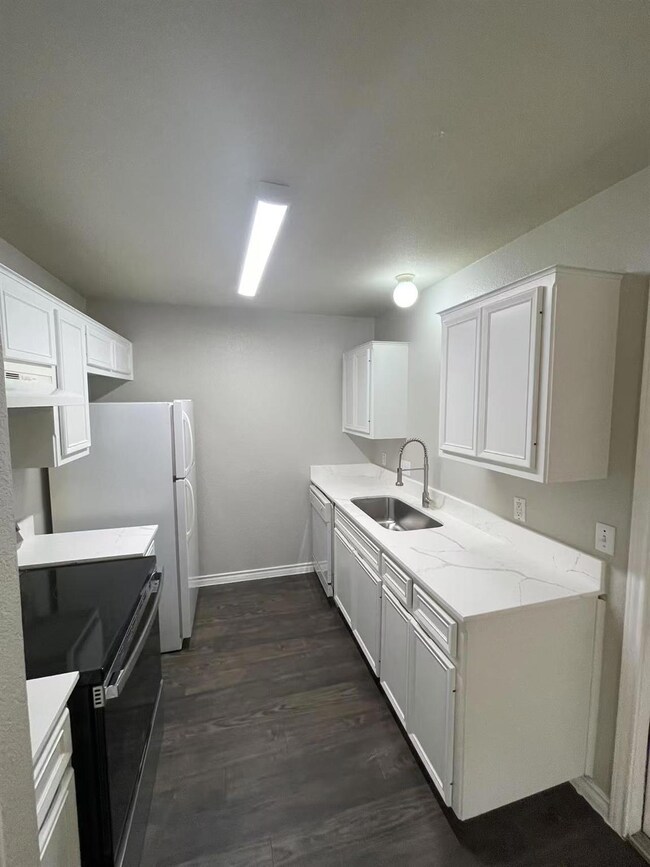 Kitchen featuring a sink, white appliances, white