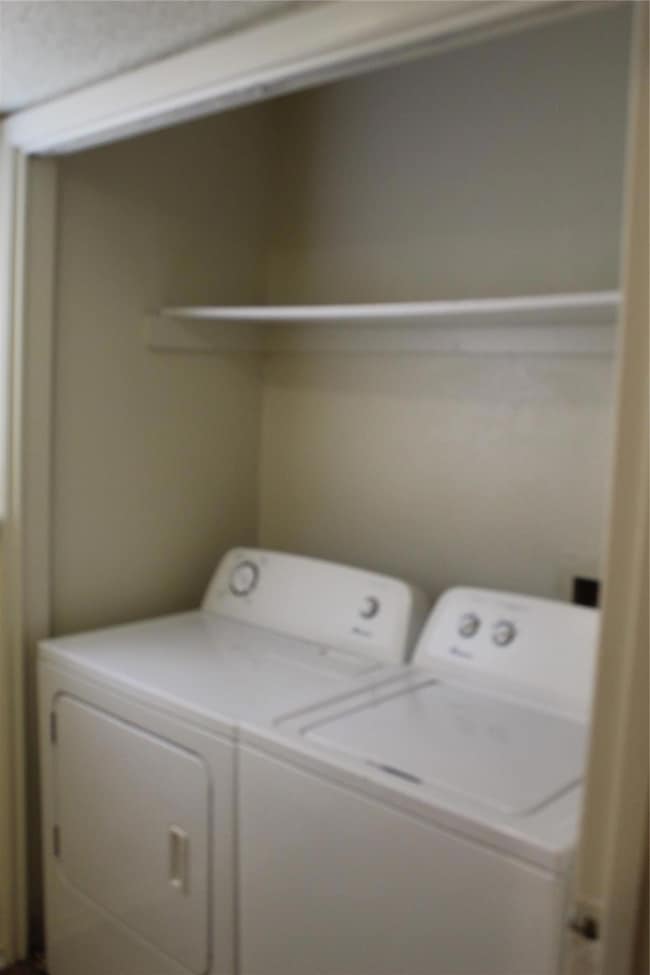 Washroom with washer and clothes dryer and laundry