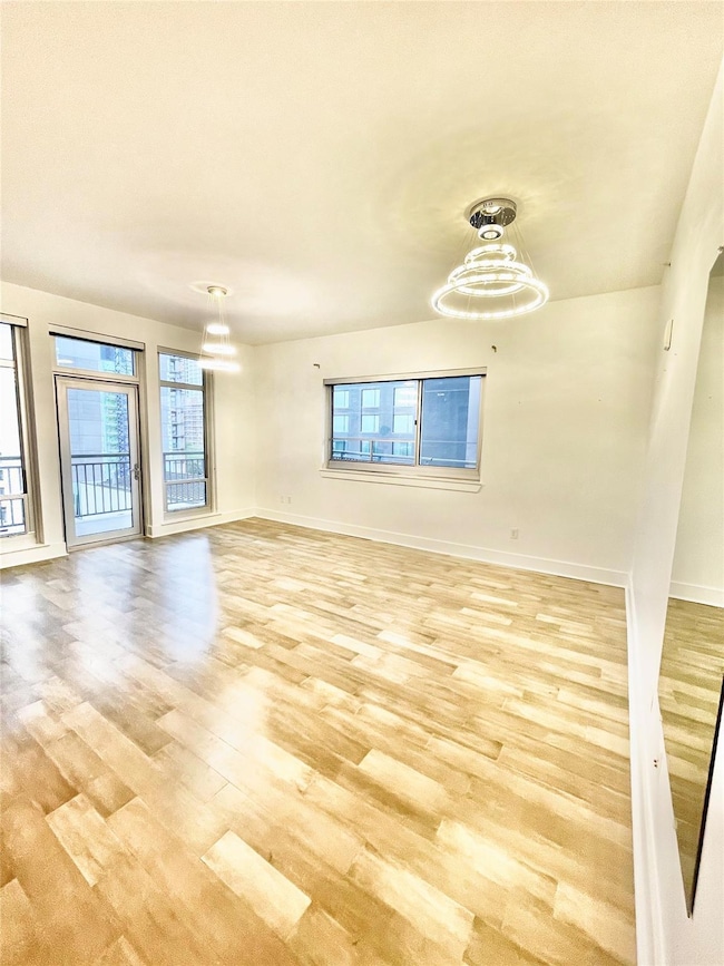 Empty room with light wood-style floors, baseboar