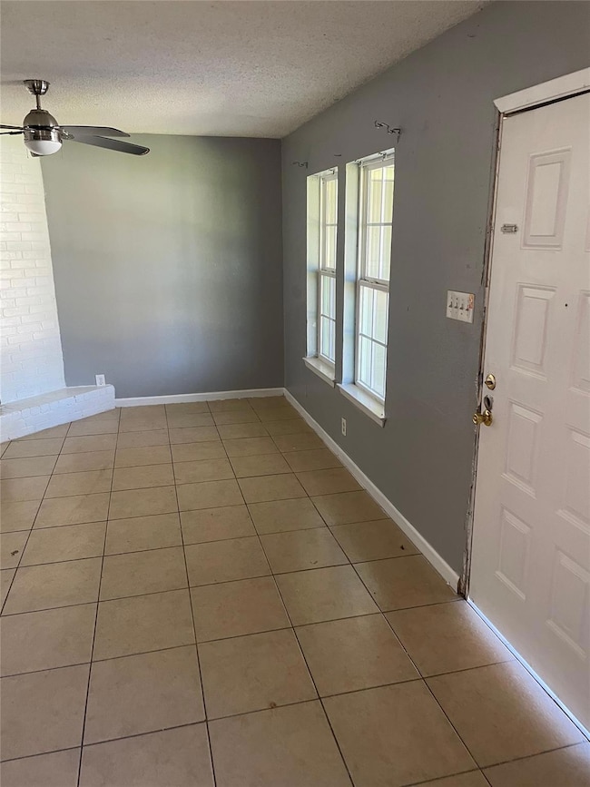 Foyer with ceiling fan, light tile patterned floo