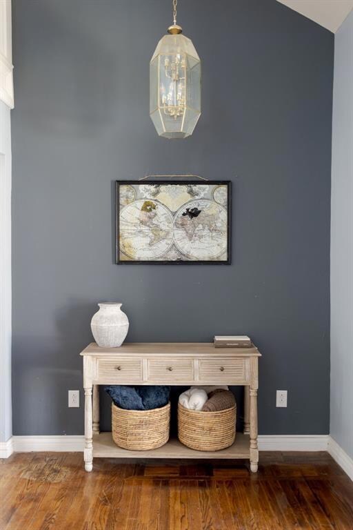 Details with baseboards, a chandelier, and wood fi