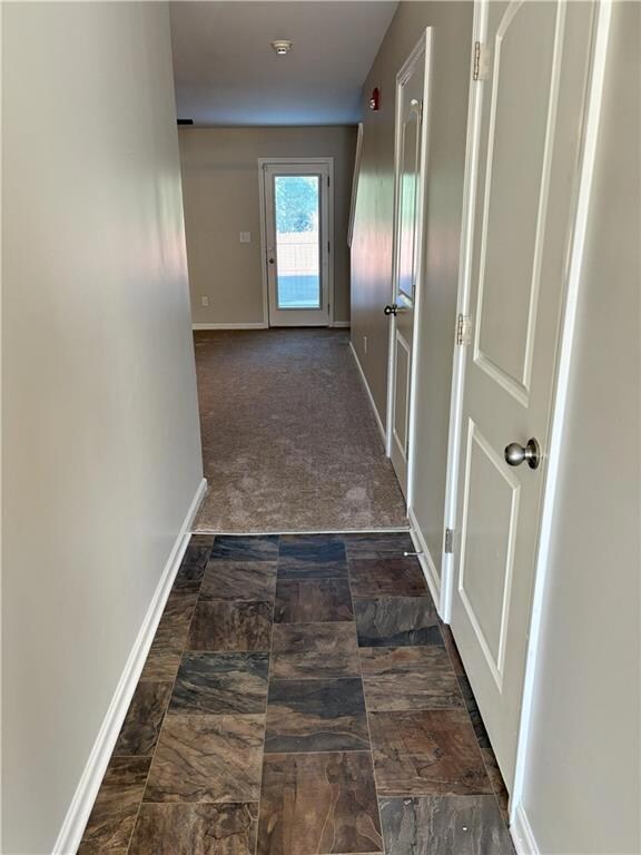 Corridor featuring baseboards