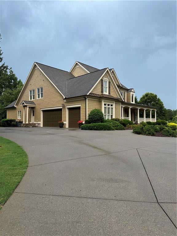 View of front of property featuring driveway, roof with shingles, and a 3 car garage