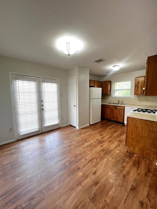 Kitchen with white appliances, a sink, light wood