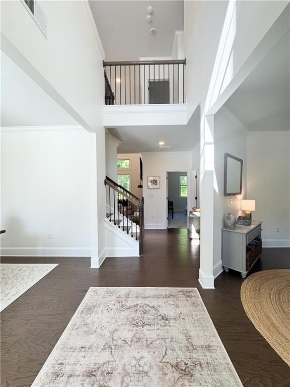 Entrance foyer featuring stairs, a high ceiling, d