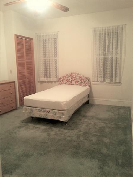 Bedroom with two closets, windows and ceiling fans