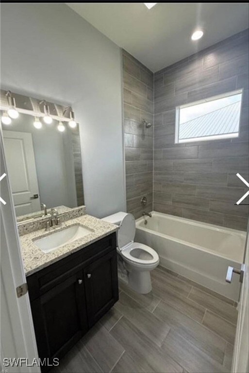 Full bathroom with shower / bath combination, vanity, and wood tiled floors