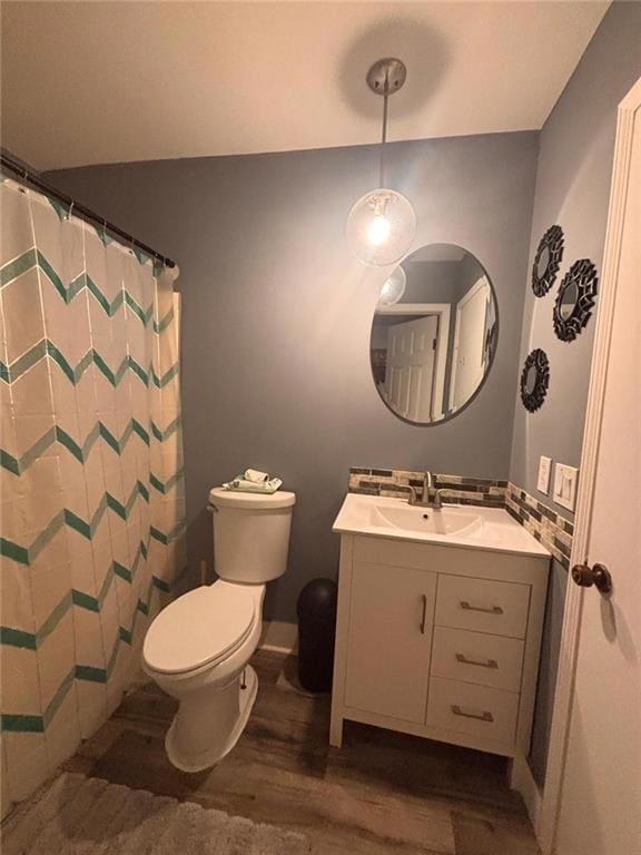 Full bath with dark wood-type flooring, vanity, and curtained shower