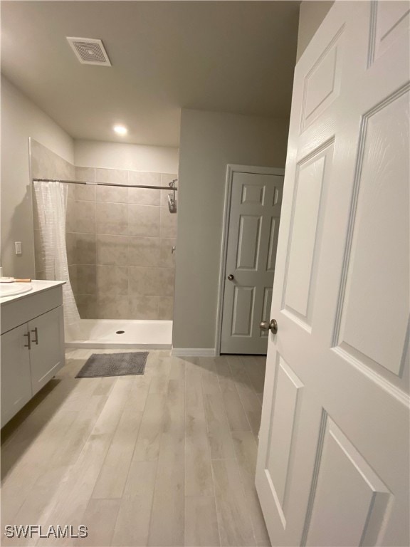 Bathroom with a shower with curtain, wood-type flo