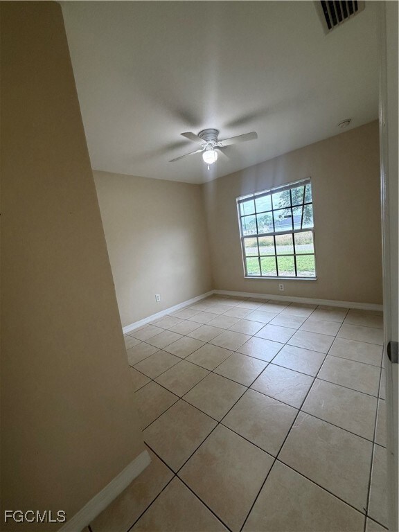Unfurnished room with light tile patterned flooring and a ceiling fan