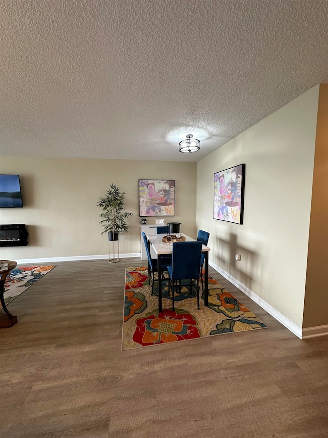 Dining area with a textured ceiling and wood finished floors