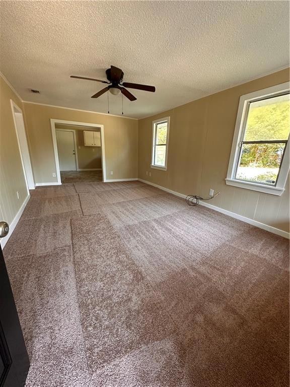 Spare room featuring carpet, a textured ceiling, and ceiling fan