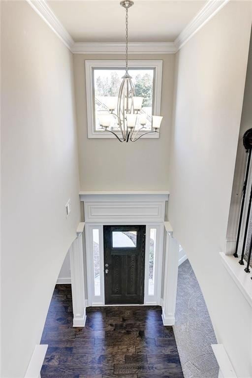 Foyer entrance with a chandelier, crown molding, a