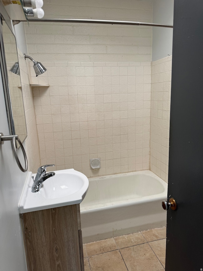 Full bath featuring light tile patterned floors, shower / washtub combination, and vanity