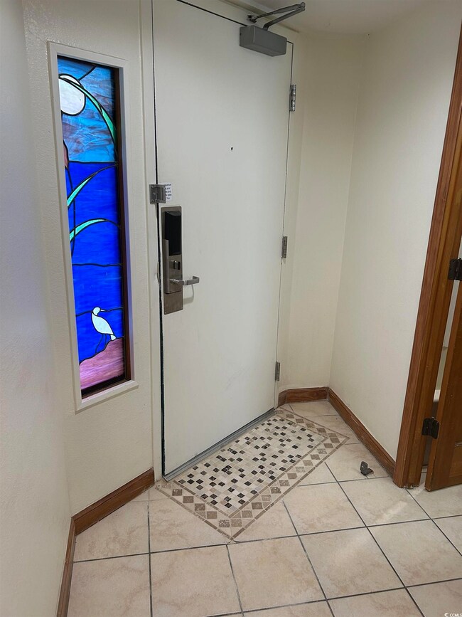 Doorway to outside featuring light tile patterned 