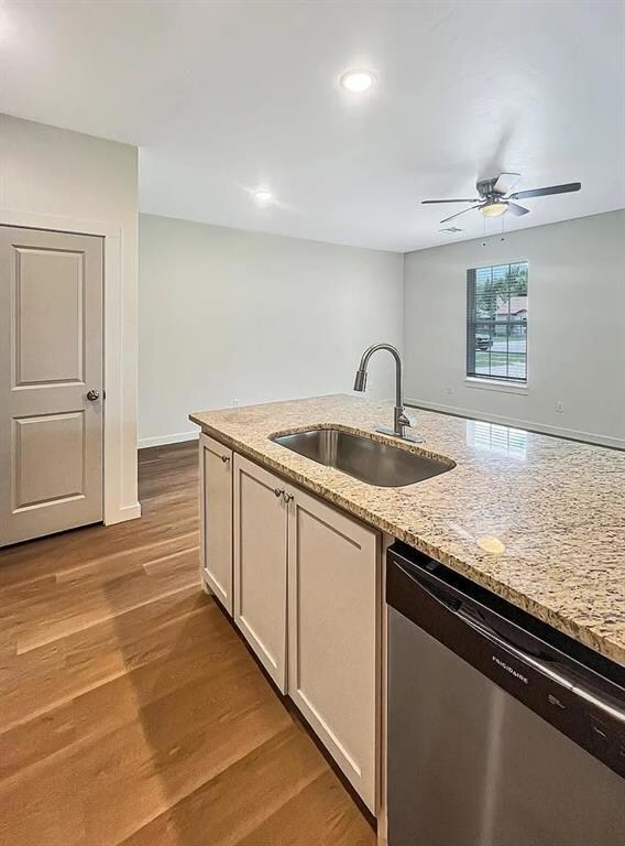 Kitchen featuring light stone countertops, a peninsula, a kitchen breakfast bar, dark wood-type flooring, and recessed lighting.Note: Photos are of a similar home by the builder.
