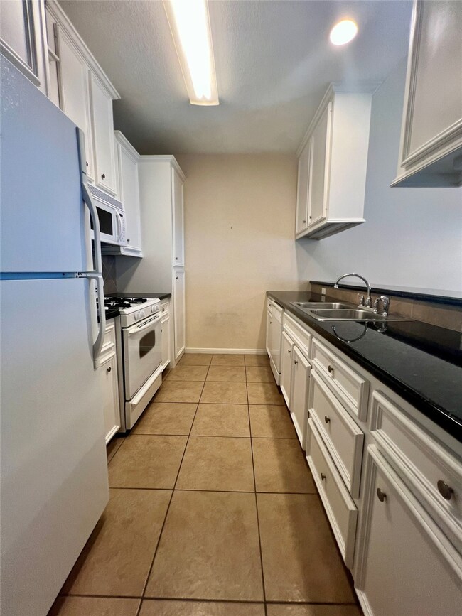 This is a galley-style kitchen featuring white cab