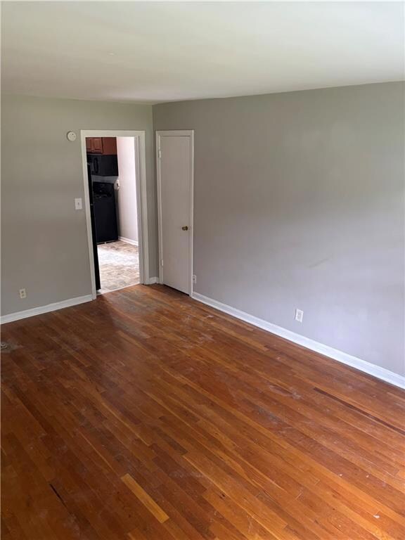 Empty room with wood-type flooring and baseboards