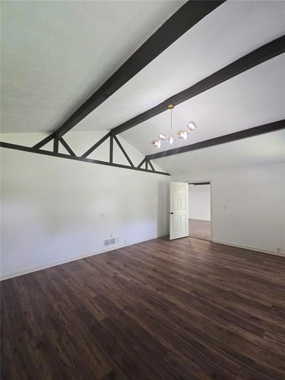 Spare room featuring dark wood finished floors and baseboards