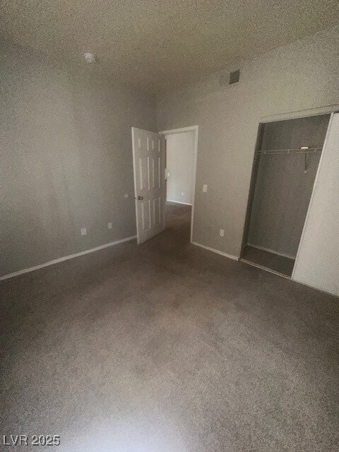Empty room featuring carpet flooring and baseboard