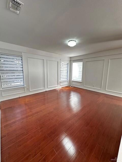 Empty room featuring dark hardwood / wood-style floors