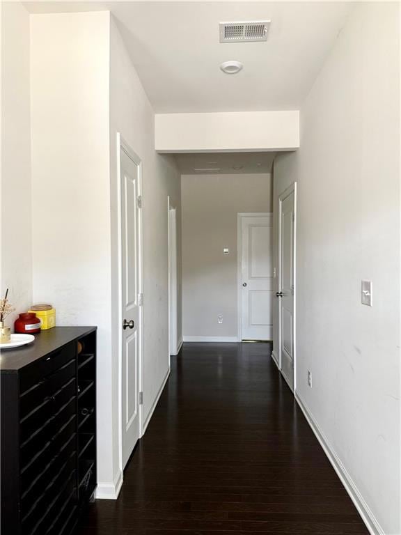 Hall featuring dark wood-type flooring and baseboards