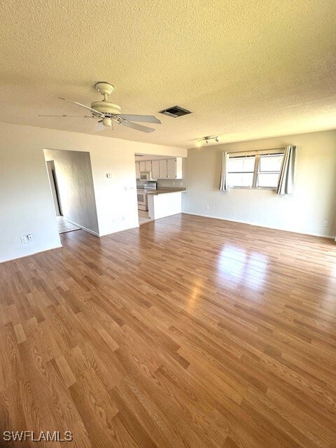 Unfurnished living room featuring visible vents, w