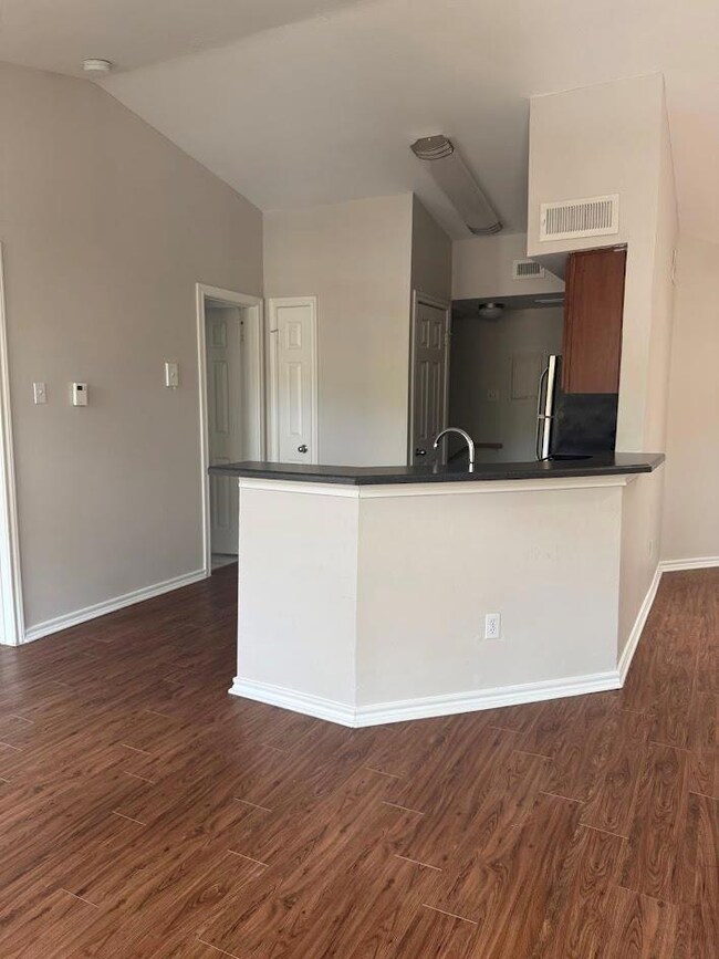 Kitchen with dark countertops, refrigerator, dark