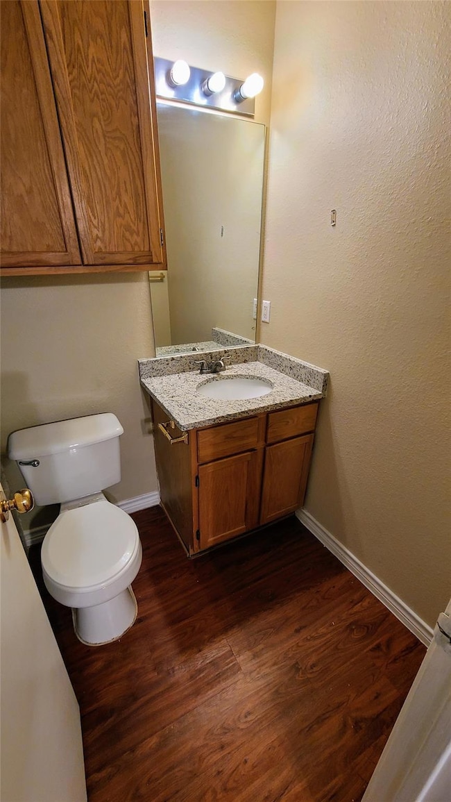 Bathroom with vanity, baseboards, wood finished f