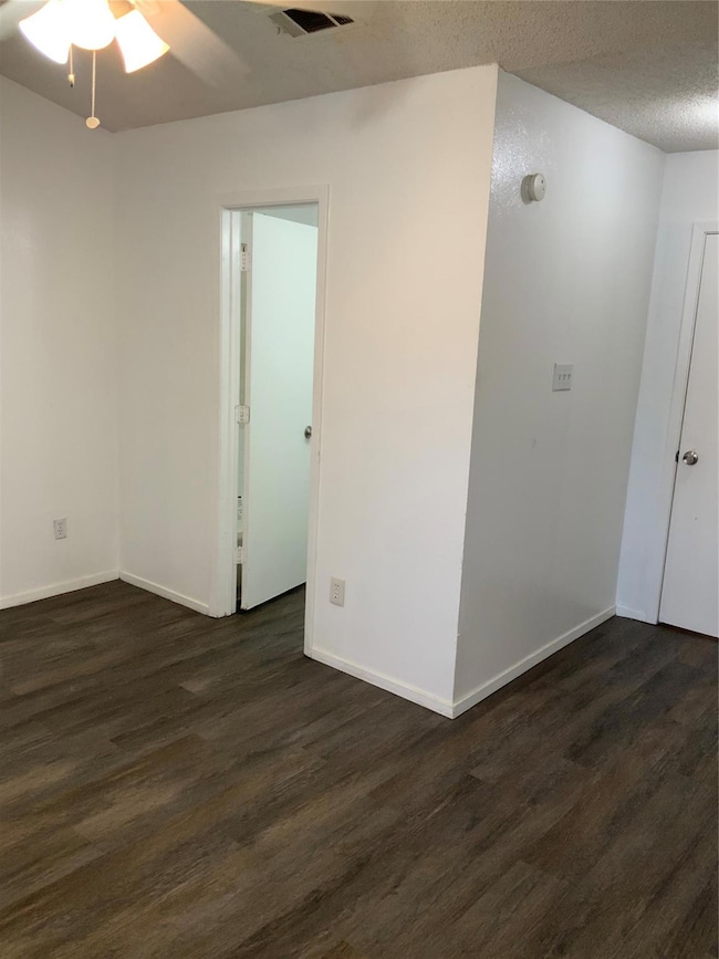 Empty room featuring a textured ceiling, visible v
