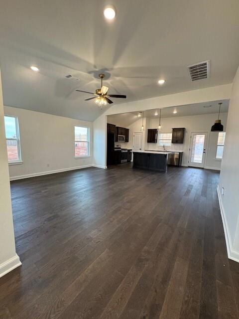 Unfurnished living room with vaulted ceiling, dark