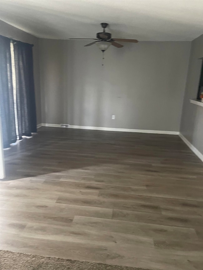 Unfurnished room featuring a ceiling fan, wood fin