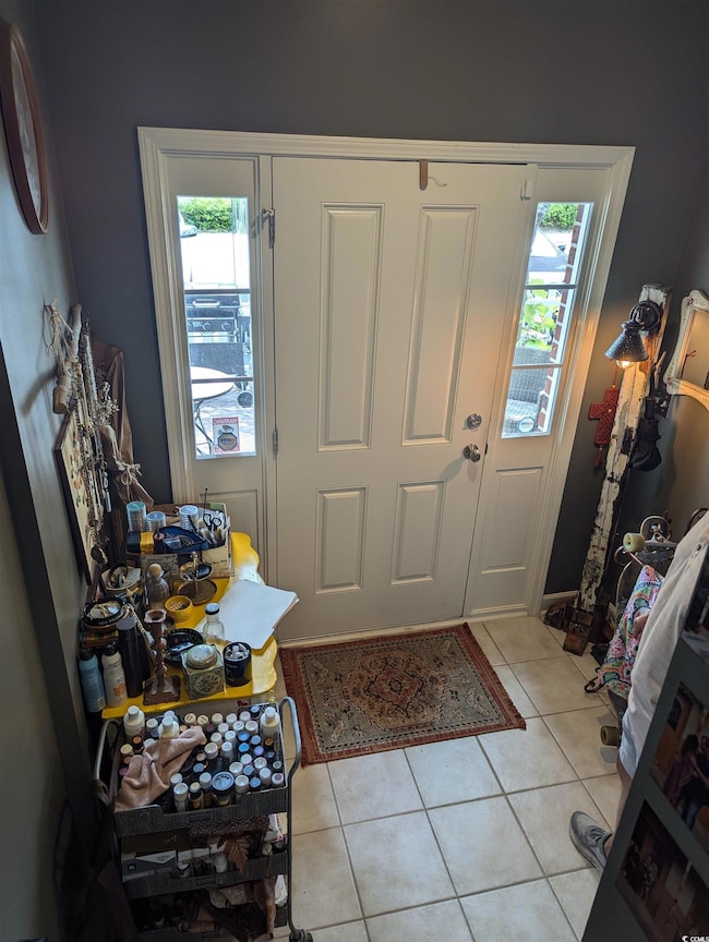 Foyer entrance with plenty of natural light and light tile patterned flooring