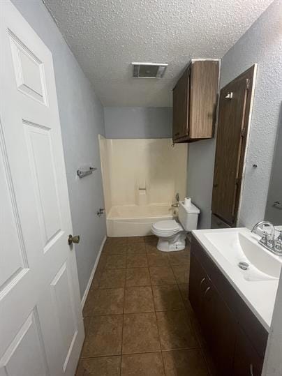 Bathroom with toilet, tile patterned floors, a te