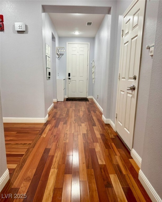 Hallway with wood-type flooring and baseboards