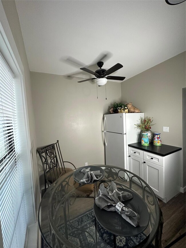 Dining room featuring ceiling fan and dark hardwoo