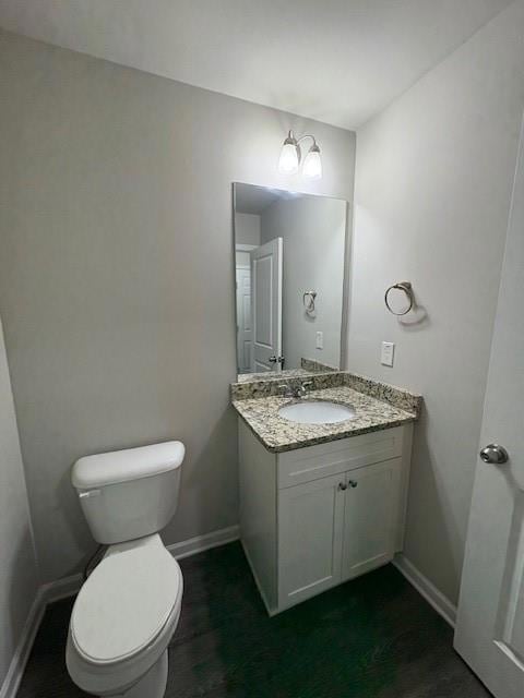 Half bathroom with vanity and baseboards